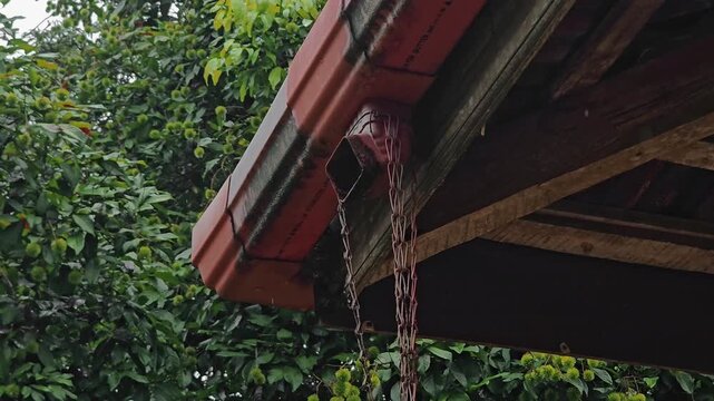 Close-up of a house gutter drainage system during heavy rain