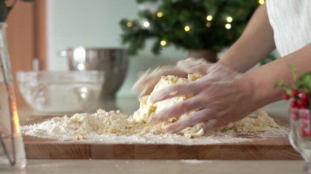 Woman's hands kneading sweet pastry dough - preparation for baking Christmas cookies