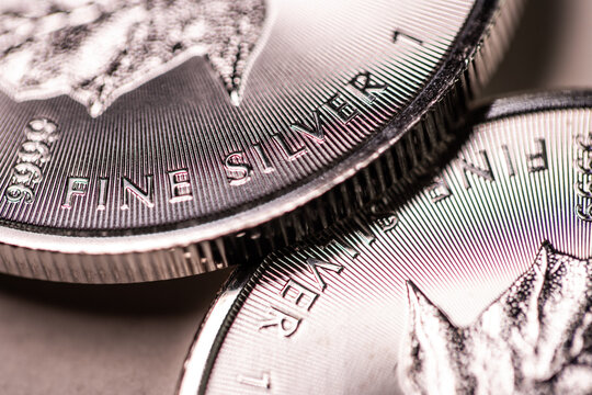 A fine silver coin resting on another silver coin, representing silver prices and critical metals.