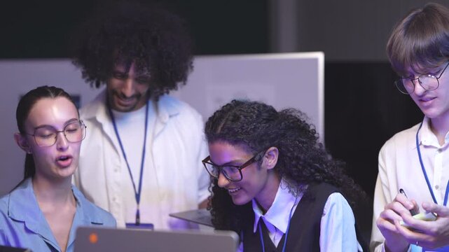 Diverse team of software engineers collaborating on AI secure coding, reviewing system logic and vulnerability parameters during a tech workshop.