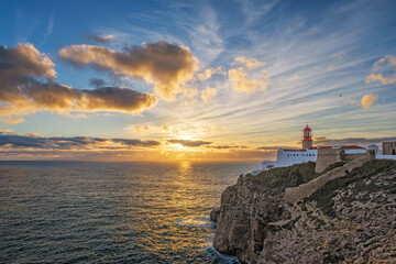 Fototapeta premium View of the Lighthouse of Cabo de Sao Vicente in Sagres, Algarve, Portugal, at sunset with Atlantic cliffs and Atlantic ocean