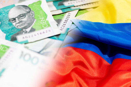 Close-up composition of Colombian 100,000-peso bills with the Colombian flag, representing the national economy, inflation, and Colombia&rsquo;s financial situation. National minimum wage
