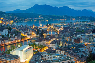 Fototapeta premium Elevated cityscape of the old city of Lucern with Lake Lucern illuminated at twilight