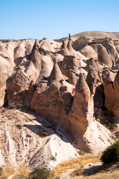 vertical photograph of fairy chimneys on a hill in Cappadocia during an August day in the Devrent Valley in Cappadocia during an August day