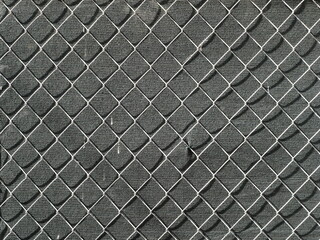 Fototapeta premium Chain link fence with diamond pattern against dark background. Front view with clear structure and geometry. Copy space.