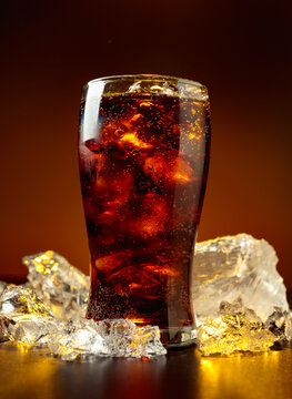 Fizz sparkling cola bubbly soda pop with crushed ice on a black table.