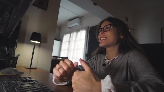 Young woman ending a work video call at home with her desk and computer. Remote work and professional communication concept.
