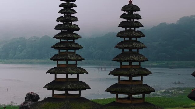 Majestic traditional Balinese water temples with tiered meru towers reflected in a serene misty lake
