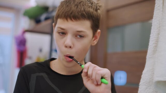White grandson brushing teeth with foam in bathroom after practice tired athlete freshening up, green brush, towel in background, reflective mood, candid closeups showing recovery routine.