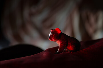 Plastic toy koala standing on a red carpet © VectorDot