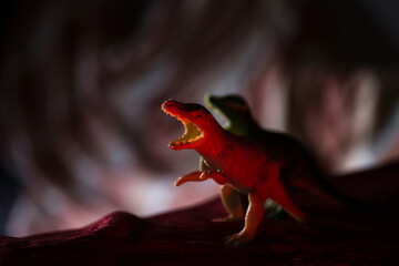 Plastic toy t-rex standing on a red carpet © VectorDot