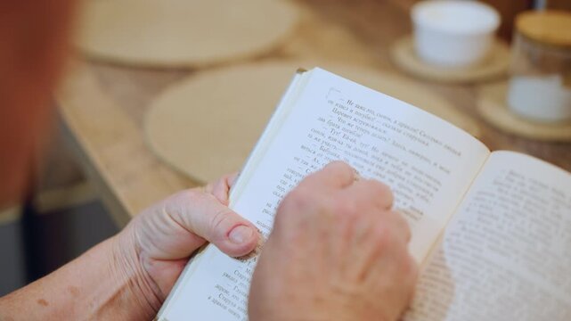 Caucasian grandma evening braille reading with tea hands turn pages near lamp saucer on table gentle ritual before rest warm cozy atmosphere slow patient routine comfort and tradition