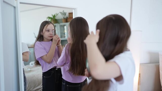 Teen girls test different shades of lipsticks on back of hands. Teenage siblings test shades of lipsticks examining texture and pigmentation