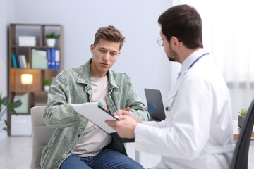 Fototapeta premium Man having appointment with doctor in clinic, selective focus