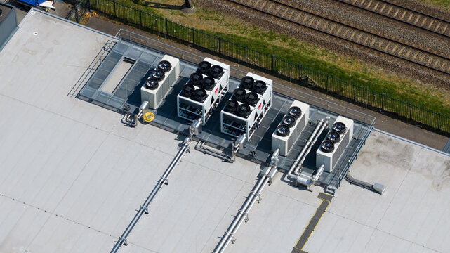 Aerial view of industrial HVAC cooling units and ventilation systems on a flat rooftop near railway tracks in Utrecht, Utrecht, Netherlands.