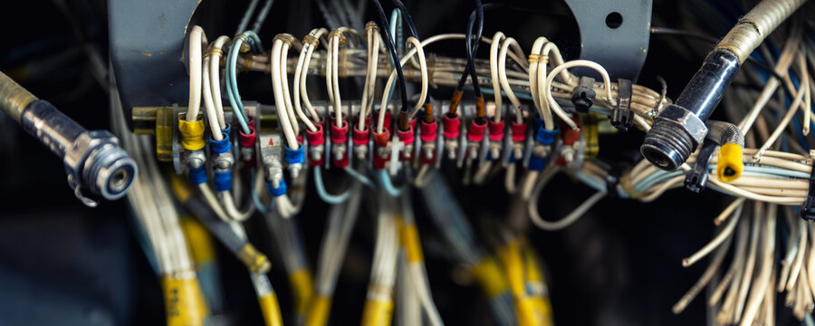 Aircraft wiring and avionics connectors inside maintenance compartment bundled cables industrial electronics. Technical aviation infrastructure show engineering systems repair service control network