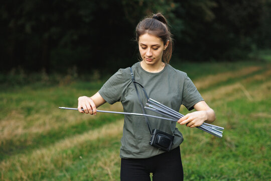 A young female tourist set up a tent in the forest