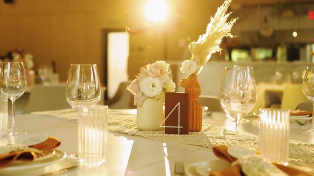 Wedding decor in a restaurant, boho style table with pampas grass and white flowers, no food.