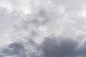 Obraz premium Cloudy sky with various shades of gray and white clouds creating a dynamic atmosphere, ideal for weather-related or nature-themed projects.