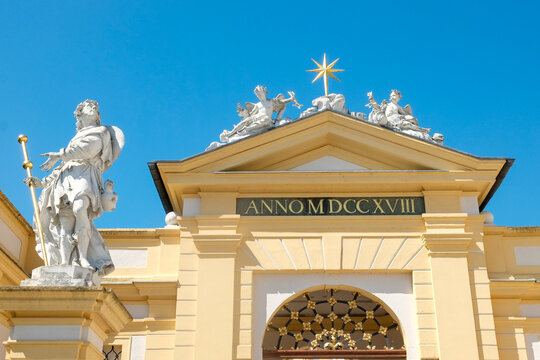 Baroque abbey entrance with statues under blue sky
