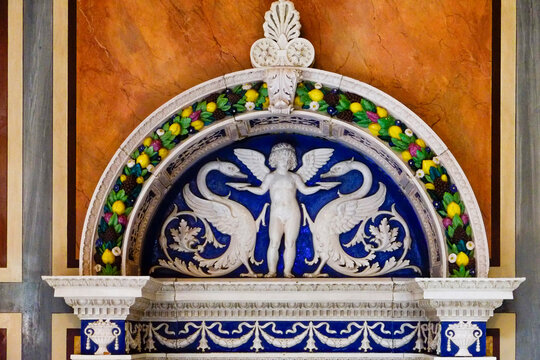 Decorative ceramic arch detail with blue figure and floral border