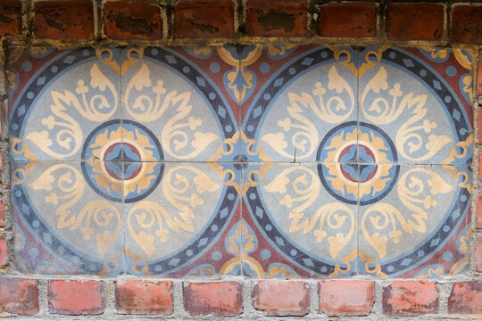 Art Nouveau ceramic tile detail on brick wall