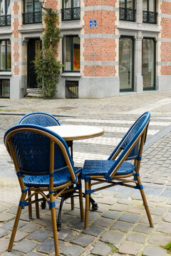 Blue cafe chairs on a quiet cobblestone street