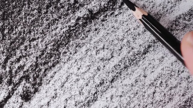 close up of charcoal pencil drawing on textured paper. slow motion footage. Background video can be used as overlay. doodling hatching