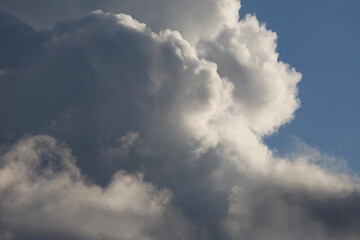 Fototapeta premium Monumental cloud formations with dramatic storm shadows and fragment of clear blue atmosphere