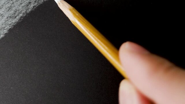 close up of chalk pencil drawing on textured black paper. slow motion footage. Background video can be used as overlay. doodling hatching