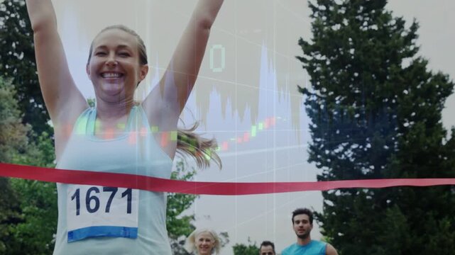 Woman bib 1671 nearing finish, breaking red tape, celebrating win while sports chart overlaying sky