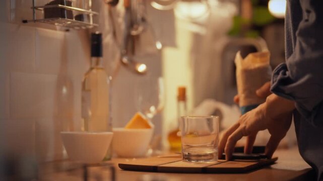 In a warm evening kitchen, a cook prepares risotto by pouring special rice into a glass container, showcasing a traditional Italian culinary process that requires attention to texture and consistency