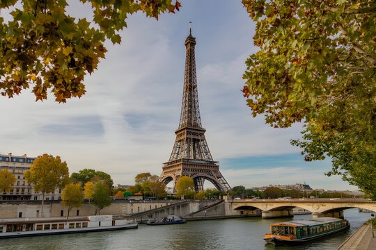 Eiffel tower framed by autumn trees along seine river