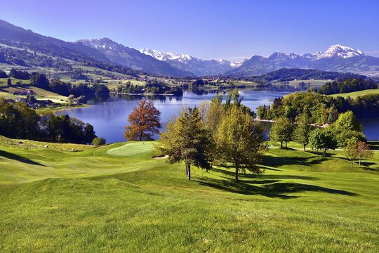 Golf course on the Lake of Gruy&egrave;re or Lac de la Gruy&egrave;re, Fribourg Alps at the back with Mt Mol&eacute;son or Le Mol&eacute;son, Canton of Fribourg, Switzerland