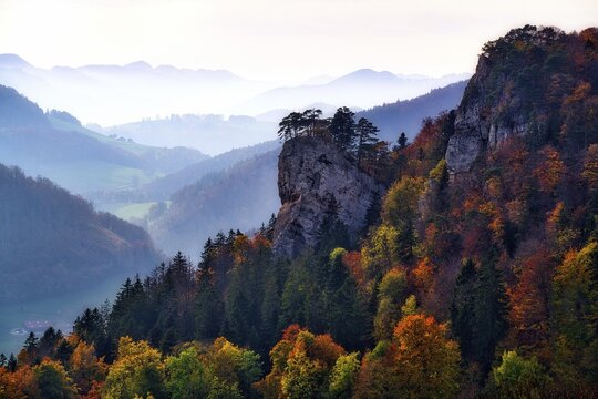 Striking rock Ankenballen juts out of the autumn forest, backlight shot with haze in the valleys, Baselbieter Jura, Canton Basel-Landschaft, Switzerland