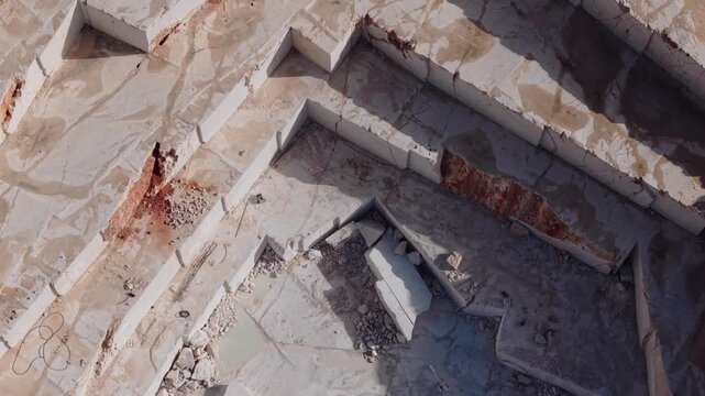 Aerial view terraced marble quarry pits and exposed stone ledges.