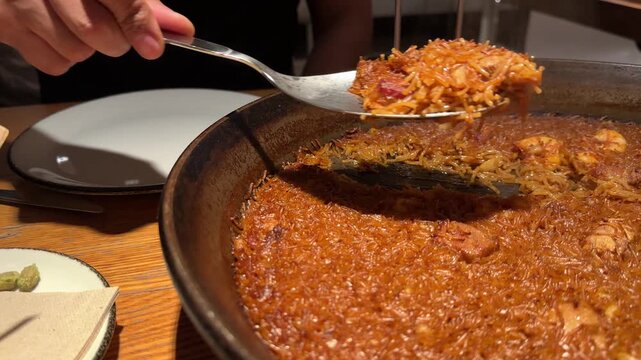 Traditional Spanish seafood fideua with tuna and mixed shellfish served in a large rustic pan on a wooden table featuring golden thin noodles savory broth and fresh Mediterranean ingredients