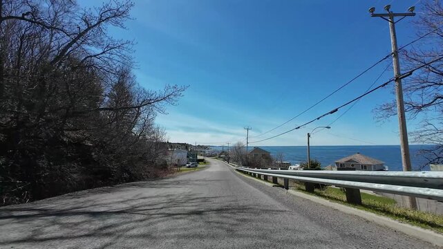 4K dashcam footage of a vehicle entering M&eacute;tis-sur-Mer via Rue Principale along the St. Lawrence River coastline in the Gasp&eacute; Peninsula, Quebec, Canada, 2026.