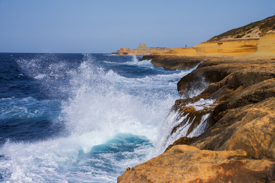 Powerful Sea Waves Crashing Against Rocky Limestone Coast at Xwejni with Qolla l-Bajda Battery in Background, Gozo, Malta