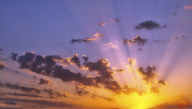 Sunbeams shining through clouds at sunrise