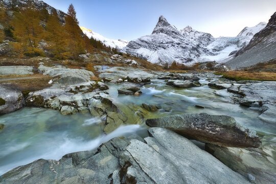 Evening mood at the brook near Ferp&egrave;cle, behind it snowy Mont Min&eacute;, Val d'H&eacute;rens, Canton Valais, Switzerland