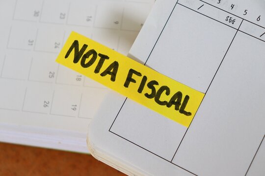 Post-it note with the words "Nota Fiscal" (Invoice, in Portuguese) on a personal planner. Concept of business accounting, tax compliance for entrepreneurs, and financial organization.