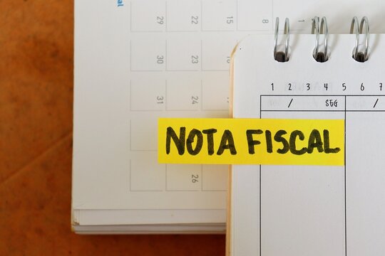 Post-it note with the words "Nota Fiscal" (Invoice, in Portuguese) on a personal planner. Concept of business accounting, tax compliance for entrepreneurs, and financial organization.
