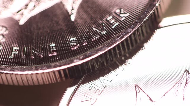 A fine silver coin resting on another silver coin, representing silver prices and critical metals.