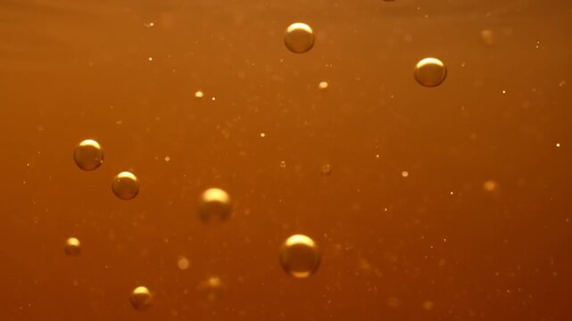 Amber carbonated drink bubbles rising, macro soda effervescence background, sparkling beverage texture for ads