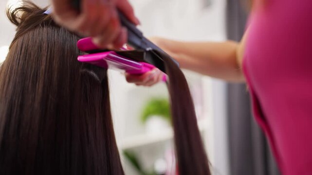 Hairdresser doing hairstyling in a beauty salon. Beautiful female hair after procedures in a hairdressing salon. High quality 4k footage