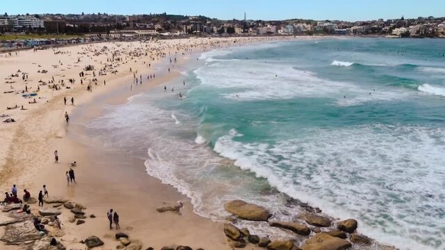 view of the beach with people far away with waves crashing on a sunny day at Sydney Bondi beach