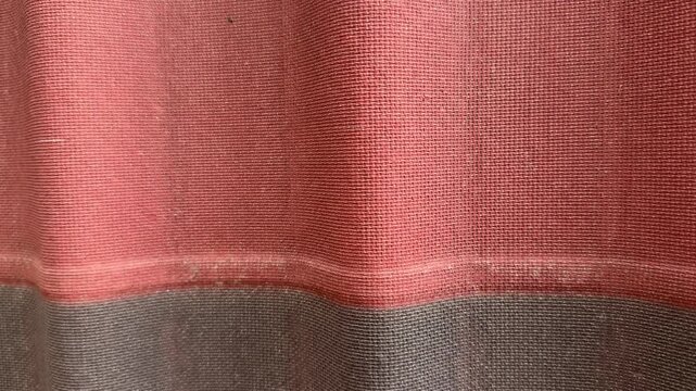 Closeup grey red ondulin roof tiles showing corrugated texture and weathered surface on cottage exterior, layered panels, subtle