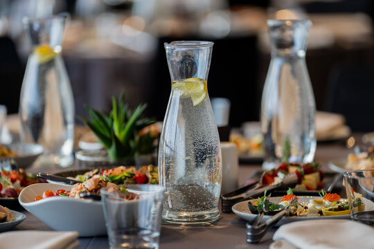 Assorted chilled beverages and healthy appetizers arranged on a dining table for a corporate function or wedding reception, highlighting modern food styling and event planning