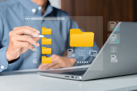 Businessman organizing digital folders and files on a virtual computer interface. Data categorization, digital asset management, administrative efficiency, and structured filing systems
